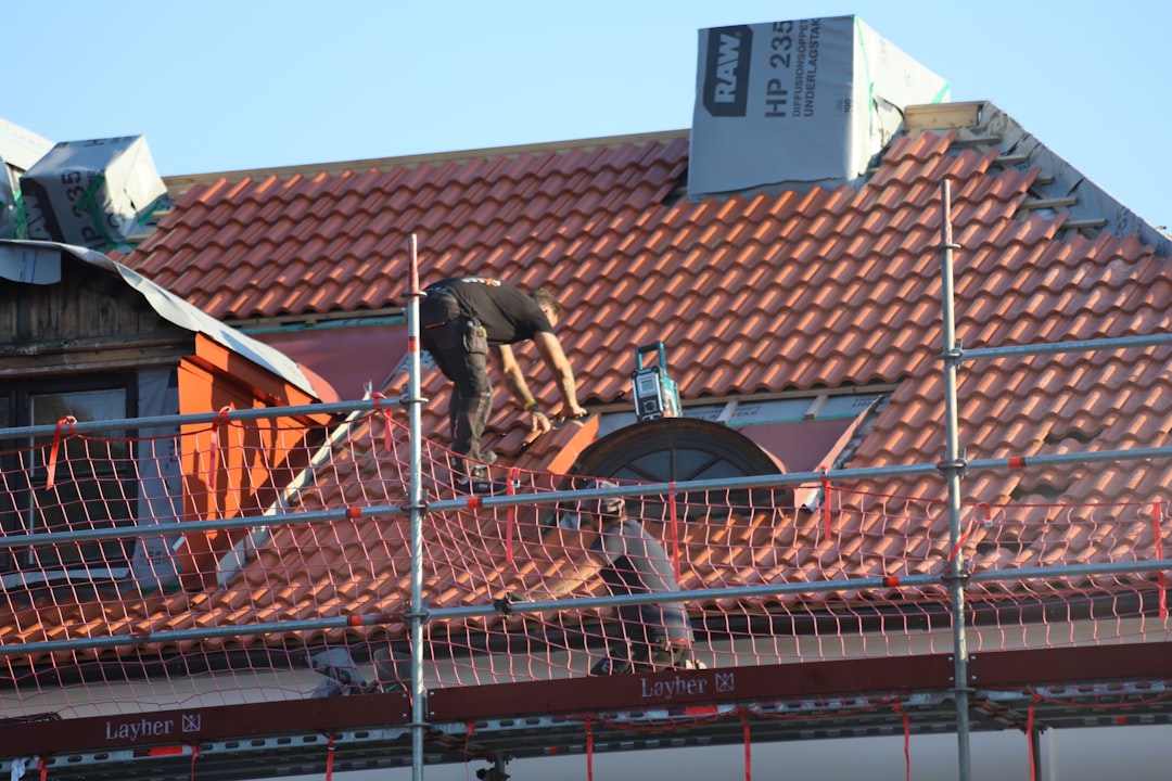 Roofer repairing tiles on a pitched roof