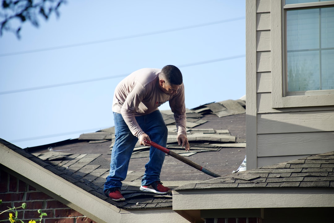 Roofer stripping old tiles from a roof before re-roofing